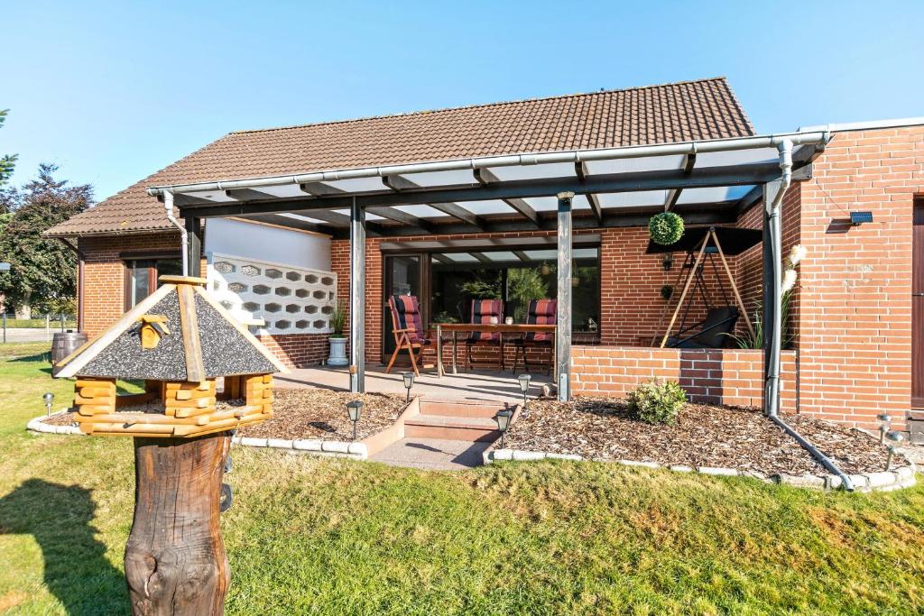 une maison en briques avec auvent et aire de jeux dans l'établissement Dörpshus, à Rehm-Flehde-Bargen