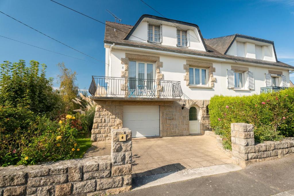 a large white house with a stone wall at Maison De Caractère in Cancale