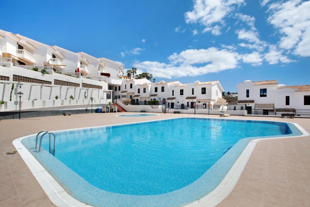 ein großes Schwimmbad vor einem Gebäude in der Unterkunft Casa Dos Ángeles in Arona