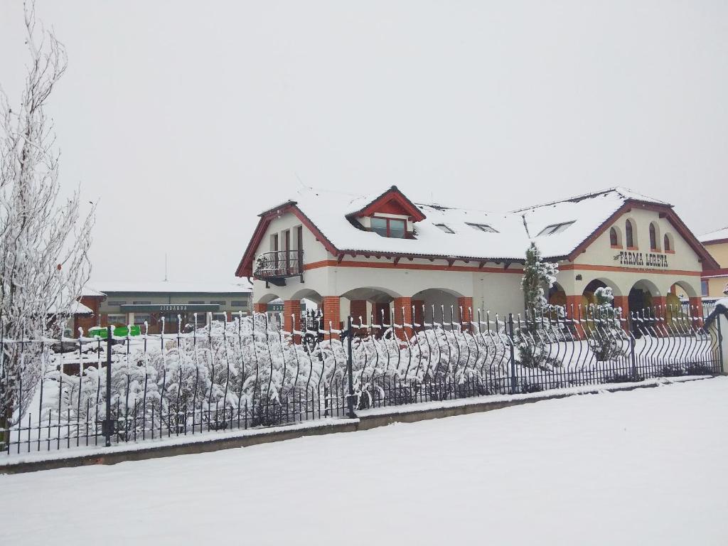 einen Zaun vor einem schneebedeckten Haus in der Unterkunft Farma Loreta in Vlašim