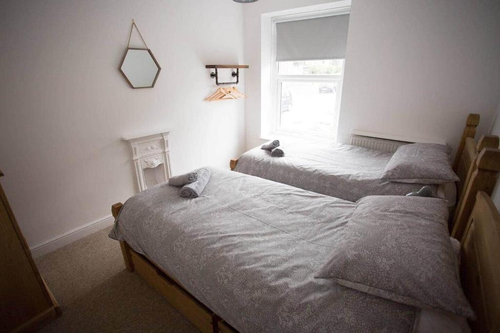 ein Schlafzimmer mit zwei Betten und einem Fenster in der Unterkunft Stone's Throw // Central Newquay // Parking in Newquay