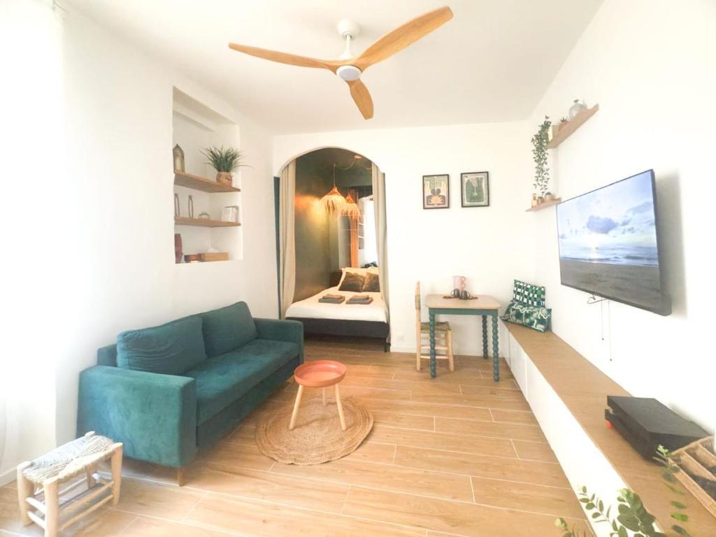 a living room with a blue couch and a ceiling fan at Mourillon proche plages in Toulon