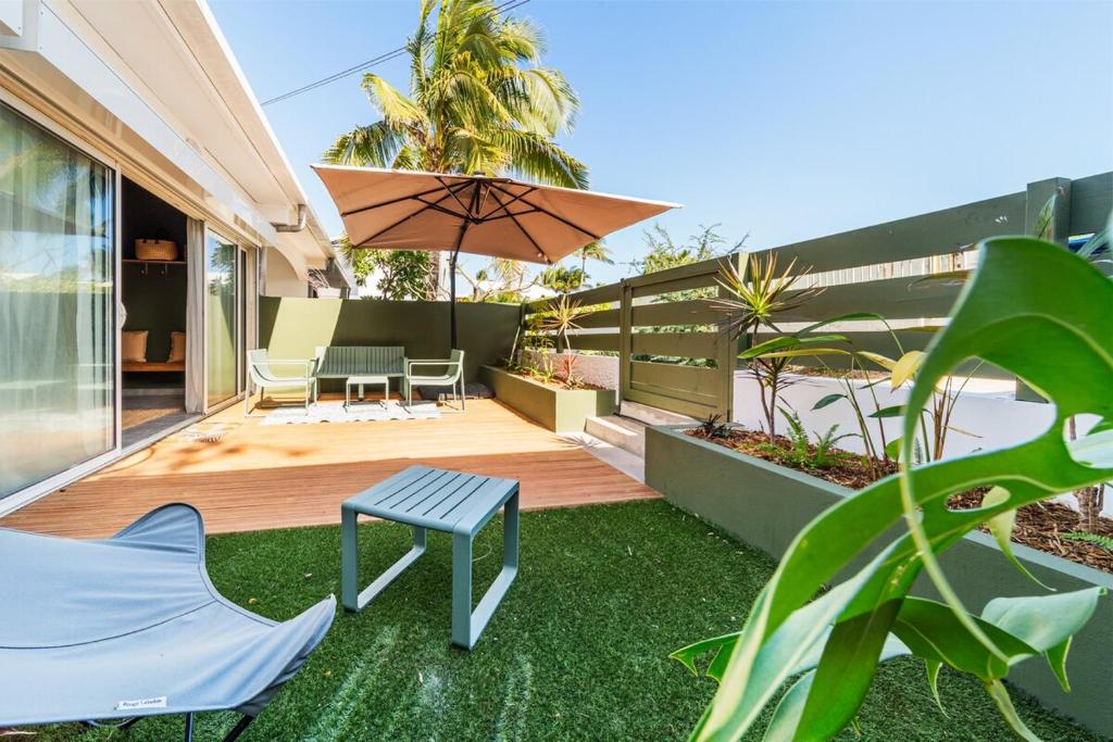 eine Terrasse mit Tisch und Sonnenschirm in der Unterkunft Villa Naroli-7pers-Jacuzzi-Plage in La Saline