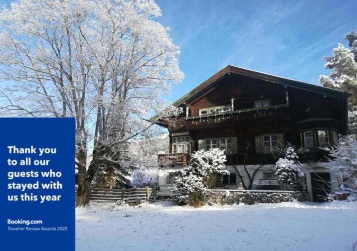 a house in the snow with a sign in front of it at Villa Momo in Kitzbühel
