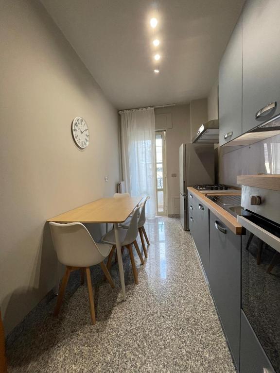 a kitchen with a table and chairs and a clock on the wall at Vibo Centro Home in Vibo Valentia