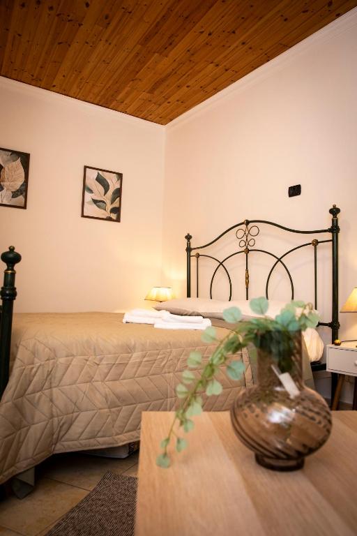 a bedroom with two beds and a vase on a table at San Nicola House in Enna