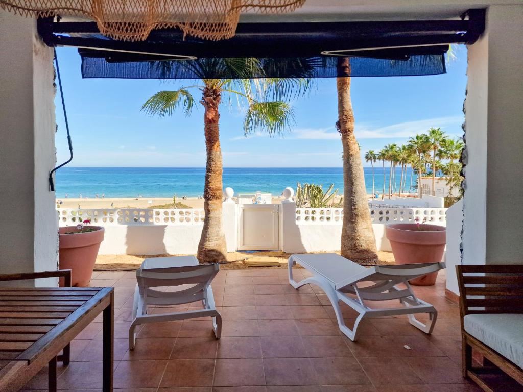 a patio with palm trees and a view of the ocean at Gold View in Costa Calma