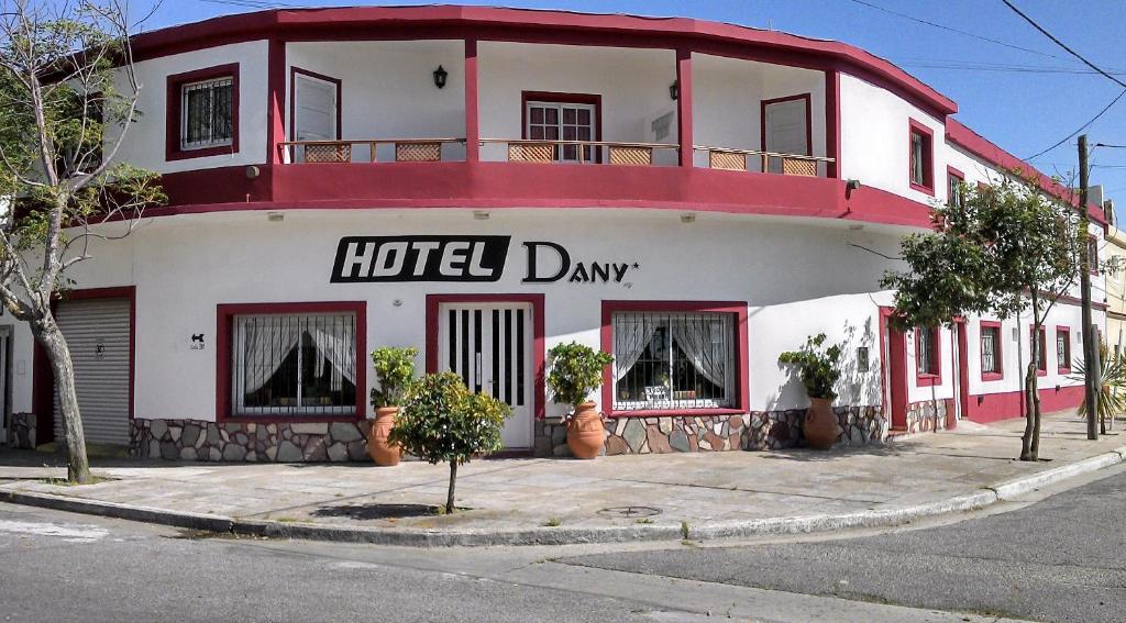 un edificio rosso e bianco con un cartello giornaliero dell'hotel di Hotel Dany a Santa Teresita