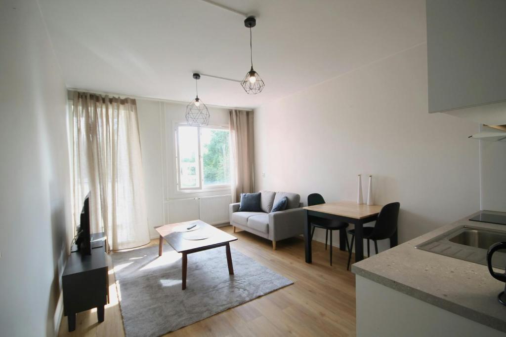 een woonkamer met een bank en een tafel bij Convenient Apartment for 2 in Kouvola