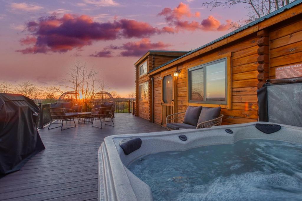 a hot tub on the deck of a log cabin at Hillside Hideaway - Hot Tub in Brookville