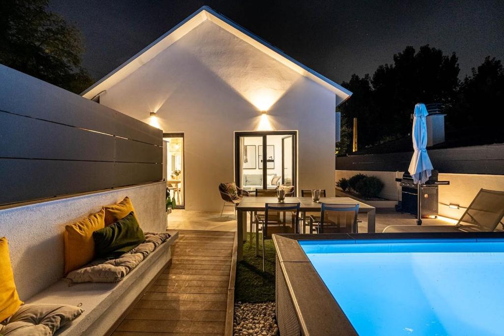 サン・クガ・デル・バリェスにあるThe Sweet House - BBQ y piscinaの夜のプールのある家