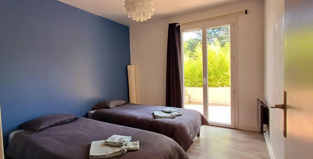 a room with two beds and a sliding glass door at Gîte Ilostou in Rivière