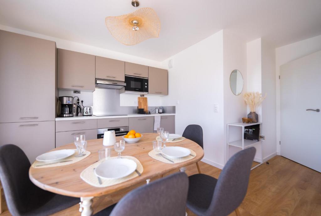a dining room with a wooden table and chairs at Sombrero - SILS in Caen