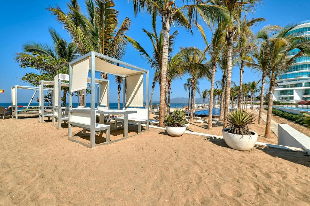 a playground on the beach with palm trees at Beachfront Duplex with Multiple Pools - Beachclub in Nuevo Vallarta