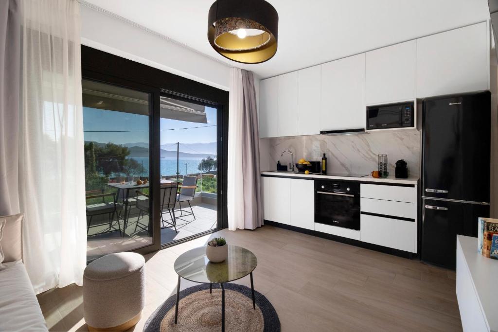 una cucina con mobili bianchi e un tavolo in una stanza di Mella Roa - Emer a Nikiana