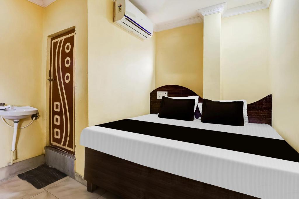 a bedroom with a bed and a sink in a room at Hotel O Sri Sai Mani Lodge in Vijayawāda