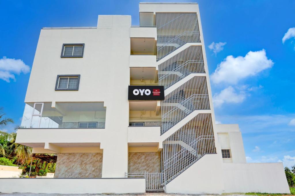 a white building with a qooc sign on it at Hotel O Sri Chowdeshwari Residency in Chik Bānavar