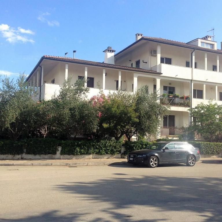 a car parked in a parking lot in front of a building at Appartamento Scossicci in Porto Recanati