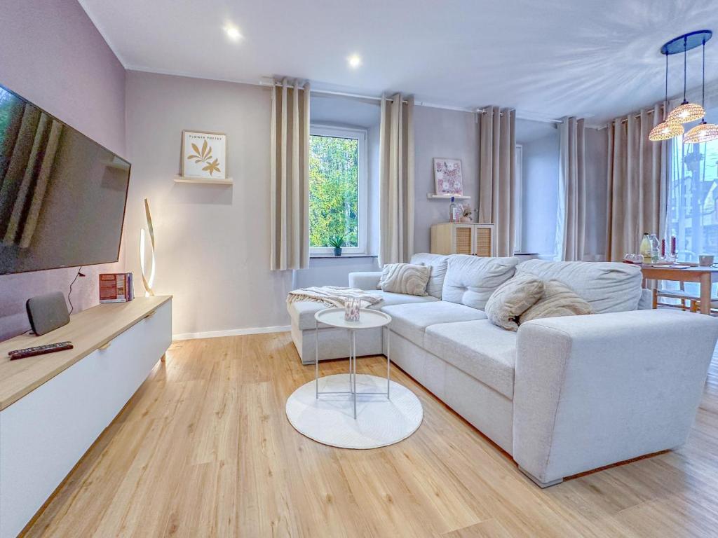 a living room with a white couch and a table at Eifelleben Hillesheim in Hillesheim