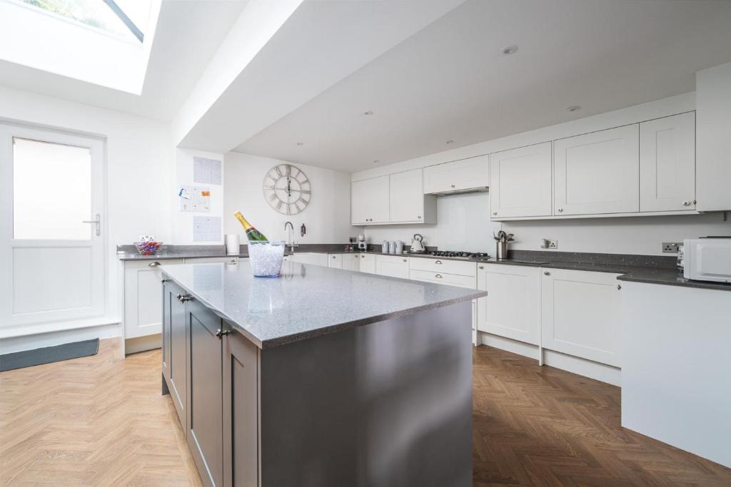 サンドゲートにあるSeafront folkestone Sandgate channel tunnel - 5 star property Sleeps 12の白いキャビネットと大きな島のあるキッチン