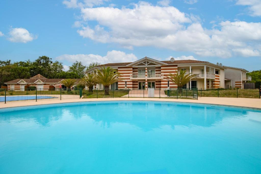 スラック・シュル・メールにあるMaison de ville Domaine des sablesの家の前の大型スイミングプール