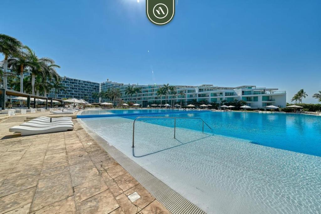 a large swimming pool in a resort with blue water at Ocean view 2BR Condo - Private Terrace - Beach in Nuevo Vallarta