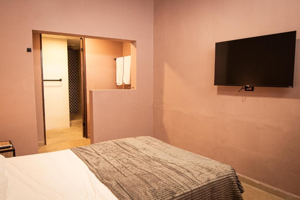 ein Schlafzimmer mit Bett und Flachbildfernseher in der Unterkunft Adhoc Barrio Antiguo in Monterrey