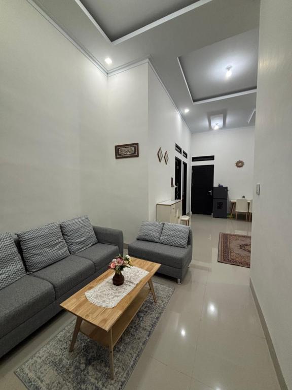 un salon avec un canapé et une table basse dans l'établissement Bundarooms Homestay Mibo, à Geutieue