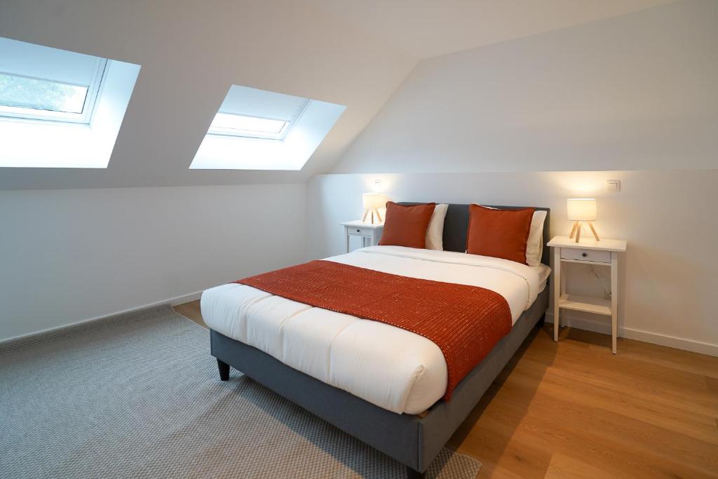 een slaapkamer met een groot bed met oranje kussens bij Appartment Douvres 7 in Brussel