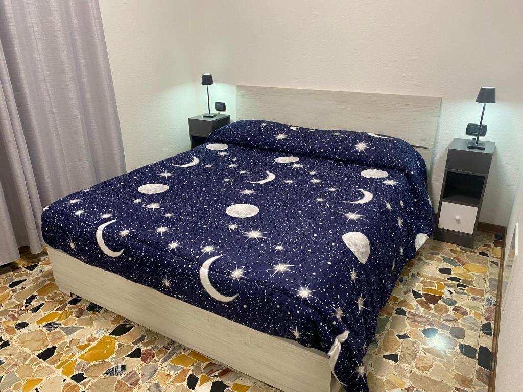 a bedroom with a bed with a blue comforter with stars at Casa Franca - Vacation Apartment in San Pellegrino Terme