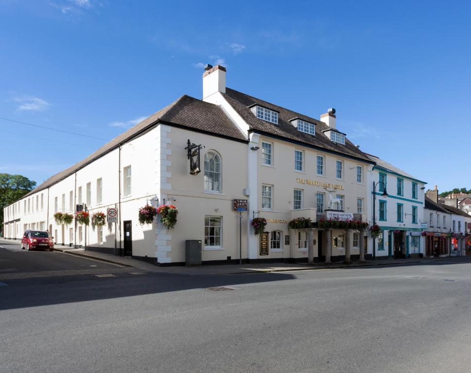 a white building on the side of a street at The White Hart Hotel Wetherspoon in Okehampton