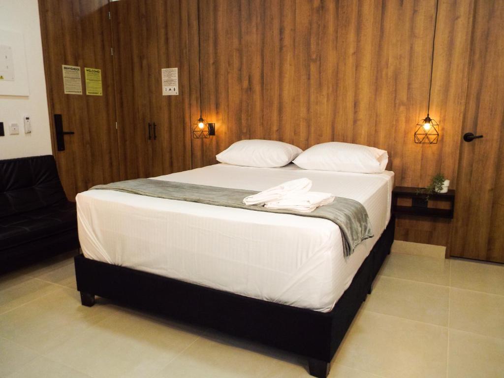 a bed with white sheets and pillows in a room at Mi Fortaleza Cali, Valle del Cauca Santa Isabel Cerca a IMBANACO in Cali
