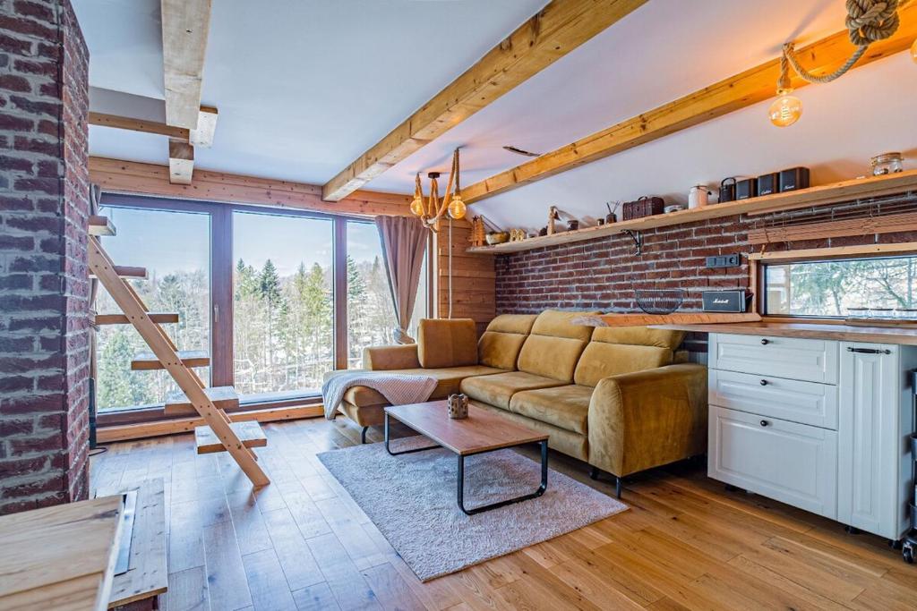 a living room with a couch and a brick wall at Chata Malenovice in Malenovice