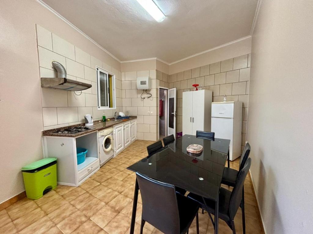 eine Küche mit Tisch und Stühlen in einem Zimmer in der Unterkunft Sea View Madeira Machico 1 Bedrooms Terrace Villa in Ribeira Seca