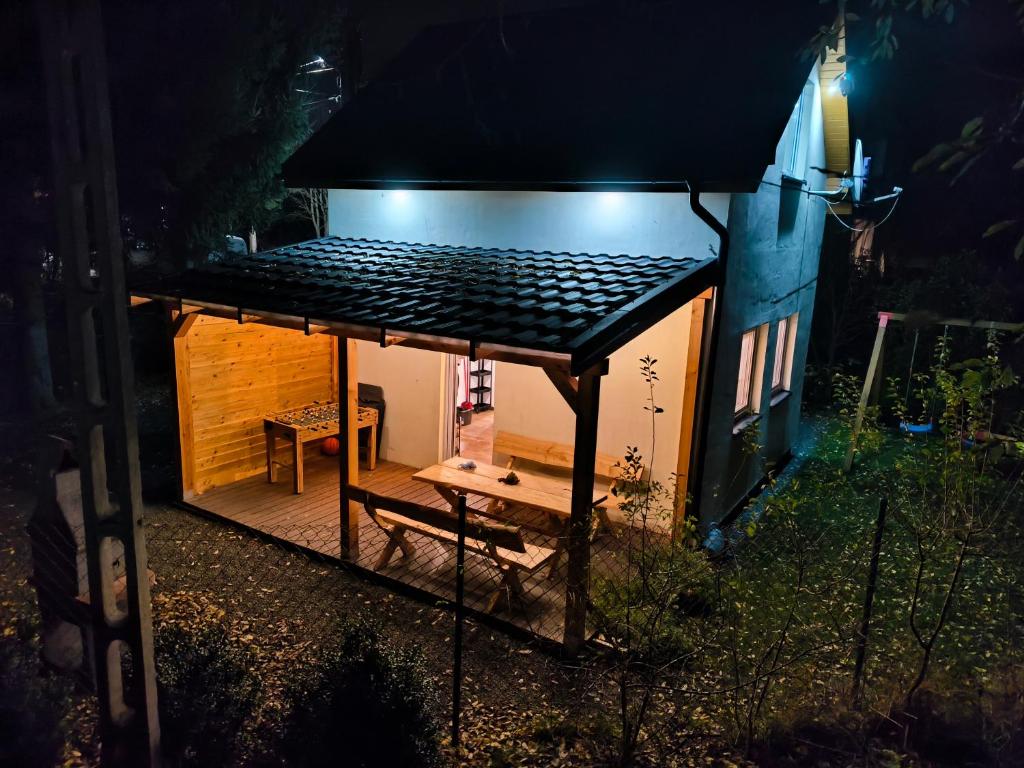 a small house with a table and a bench in front of it at Holiday House Lawendowa Przystań - dom z jacuzzi nad jeziorem in Miszkowice