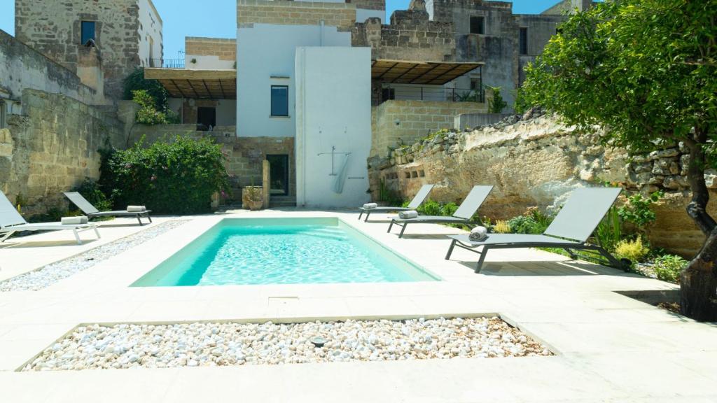 a swimming pool with two lounge chairs next to a building at Dimora Zenieri – Terrazze & Piscina in Casarano