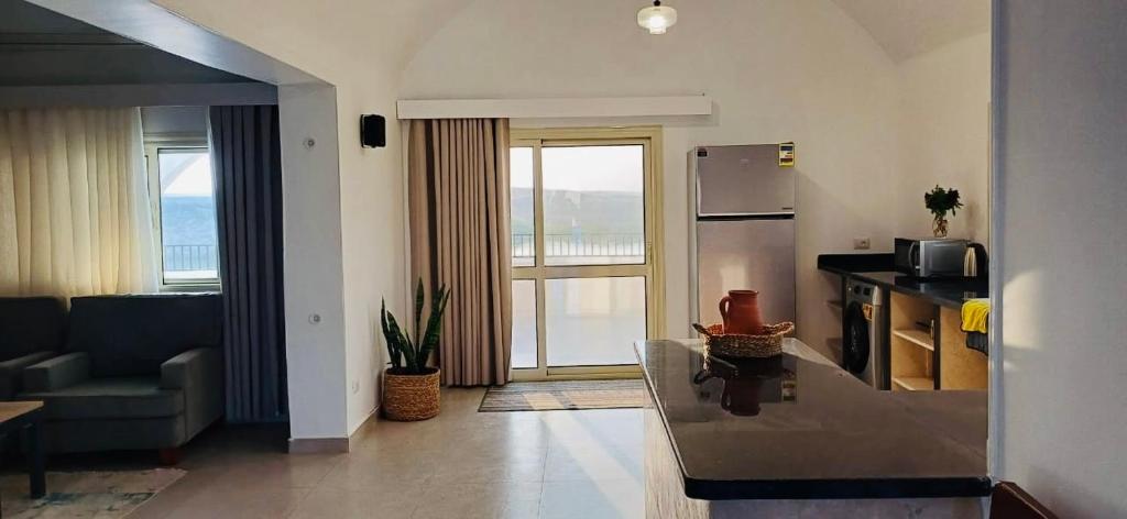 a living room with a couch and a kitchen with a microwave at Golden Sun House I in Abu Simbel