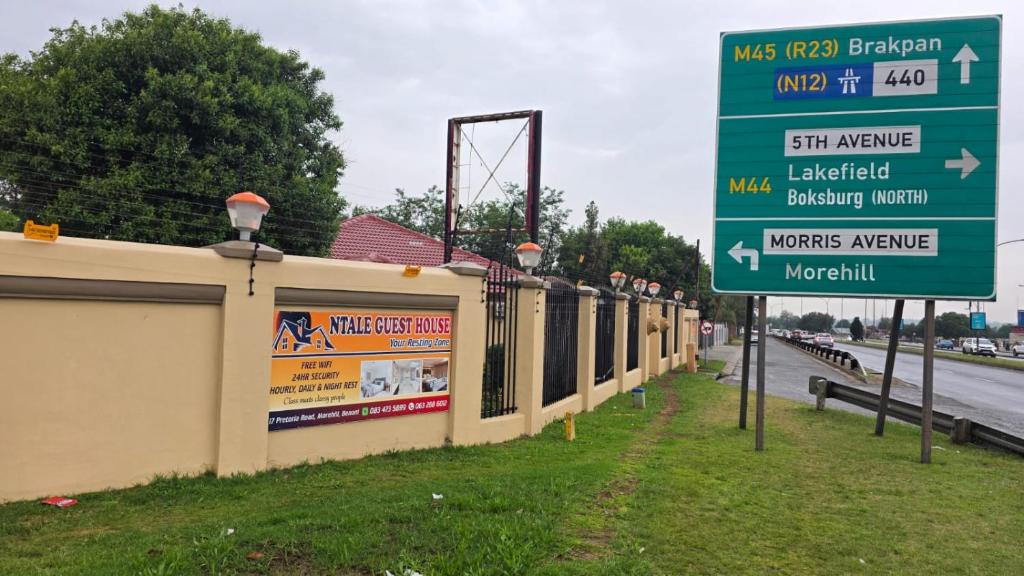 a street sign next to a building and a highway at Ntale Guest House in Benoni