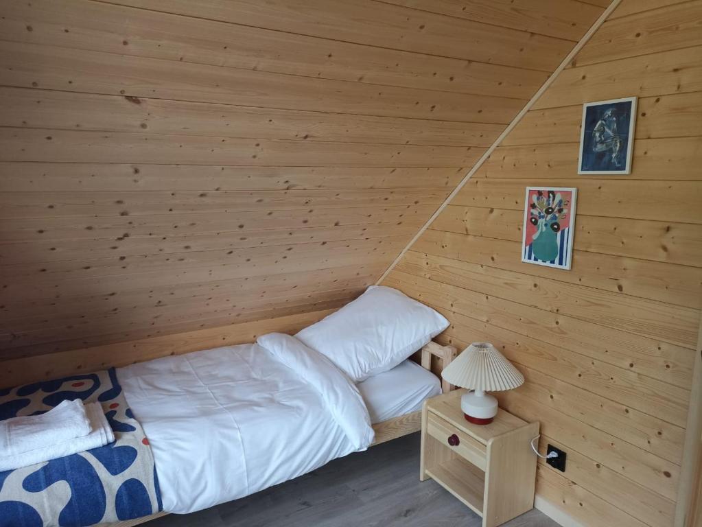 a bedroom with a bed in a log cabin at Domek Pod Jemiołami - Mały Głęboczek in Mały Głęboczek