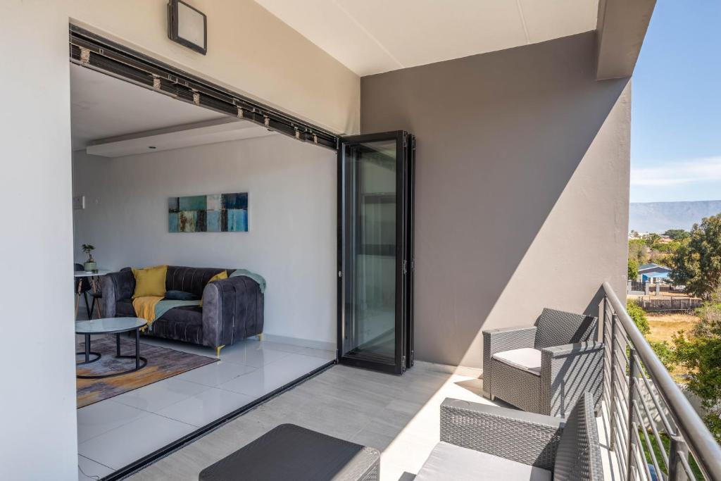 a balcony with a couch and a table at Greystone Serenity 2-Bedroom Apartment in Cape Town