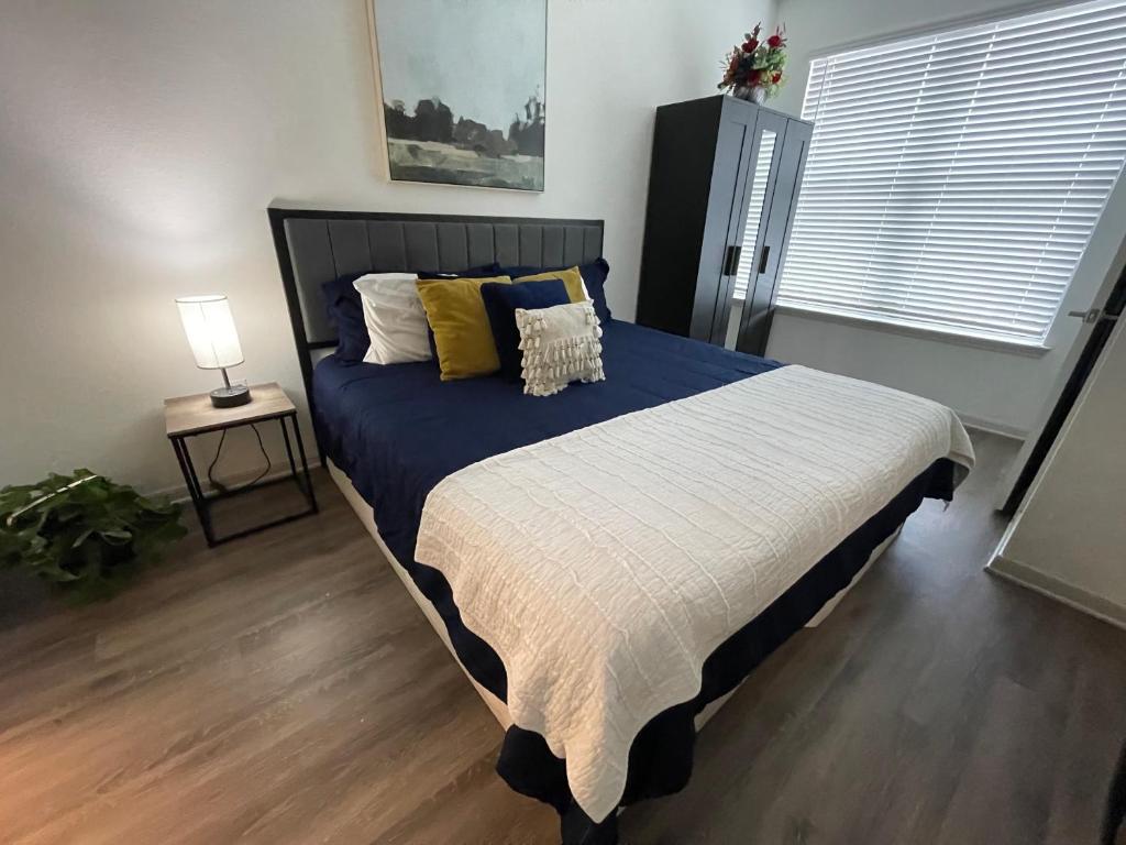 a bedroom with a bed with a blue blanket and yellow pillows at Centrally-Located 1BR Suite with Resort Pool View in Frisco