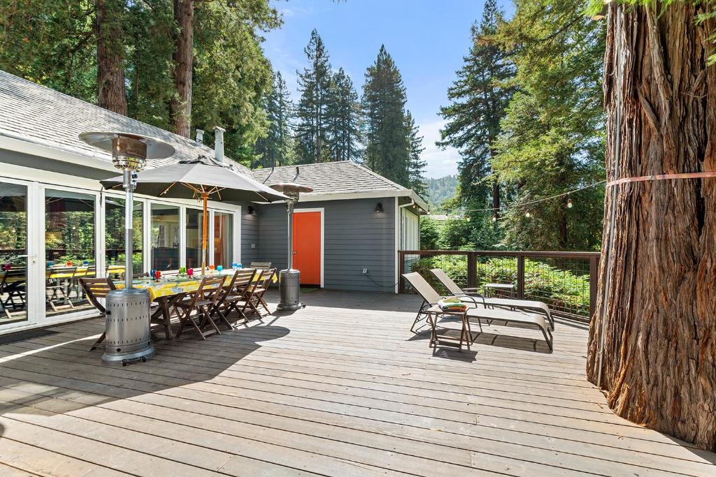 a wooden deck with chairs and a table and an umbrella at The Sandy Star in Guerneville