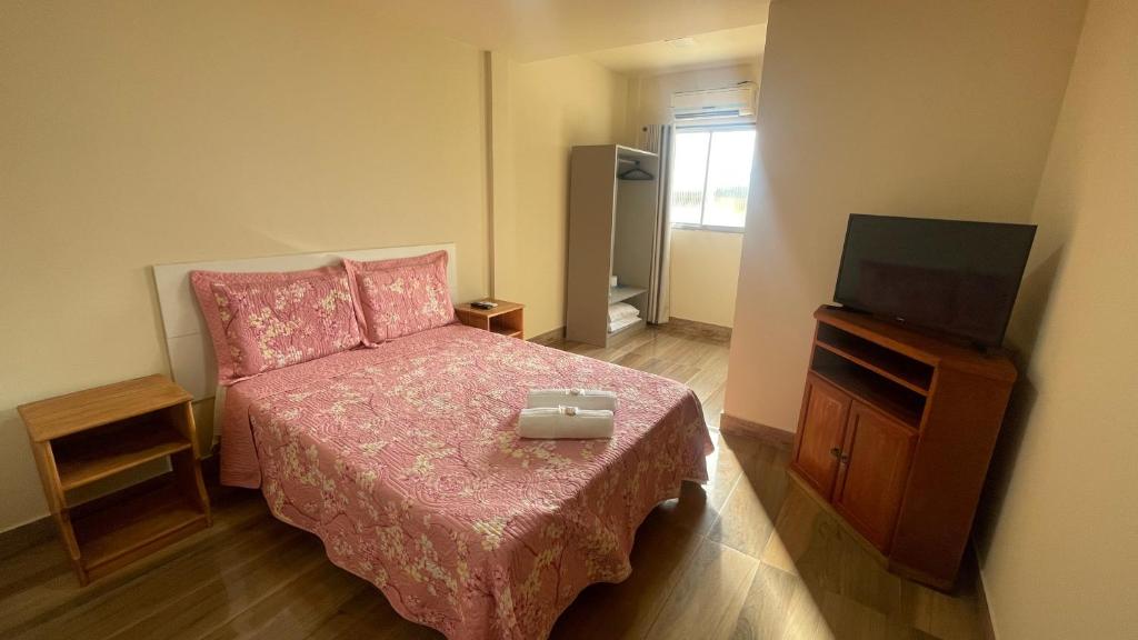 ニテロイにあるCaminho de Itacoatiaraのベッドと薄型テレビのある寝室