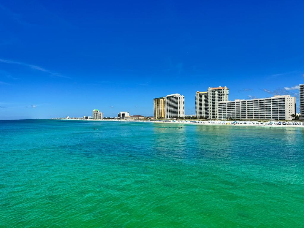einen Blick auf das Meer mit einer Stadt im Hintergrund in der Unterkunft Kokomo Key on Navarre Beach - Private Pool in Navarre