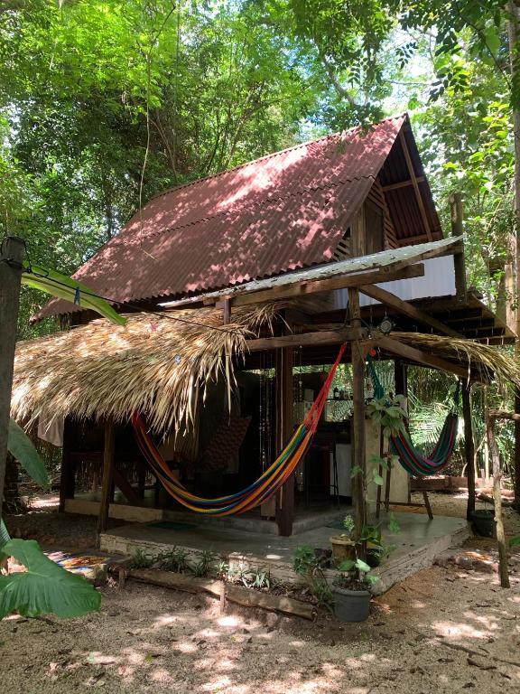a hut with a thatched roof and a hammock at Casa Embira - 300 metros da Praia do Lago Verde in Alter do Chao