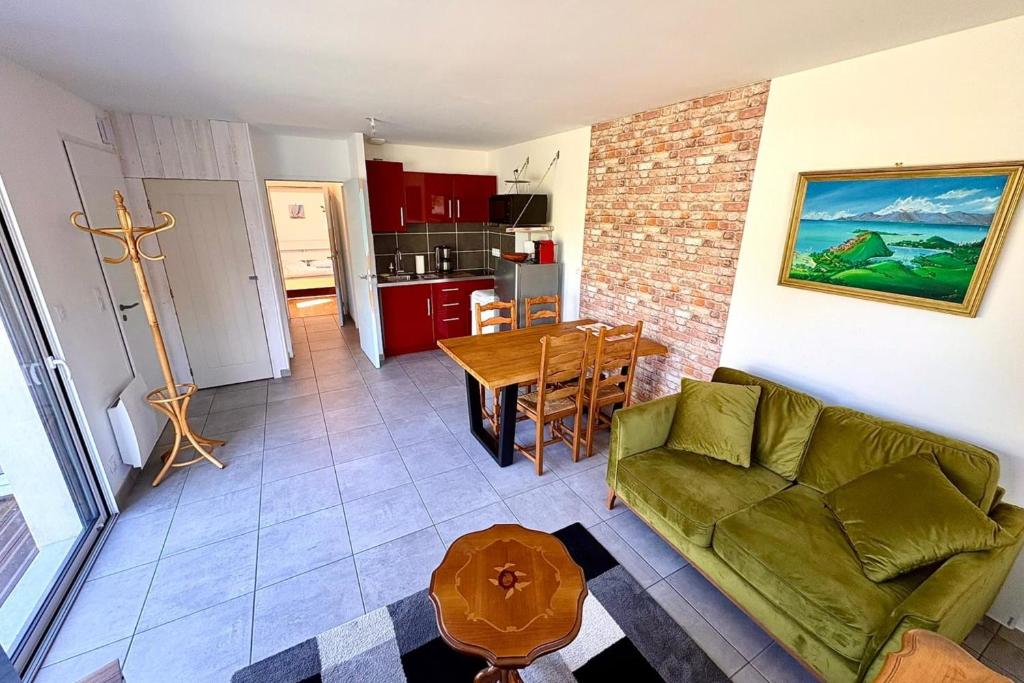 a living room with a green couch and a table at Bright house with garden in Saint-Sébastien-sur-Loire