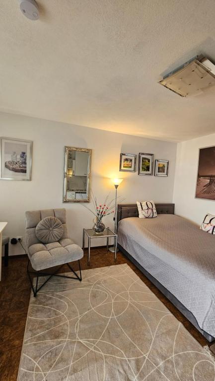 a bedroom with a bed and a chair at Ferienwohnung Bad Bergzabern in Bad Bergzabern