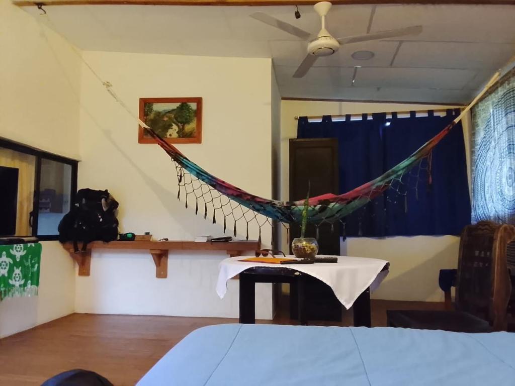 a room with a table and a hammock at Shark House in Bellavista