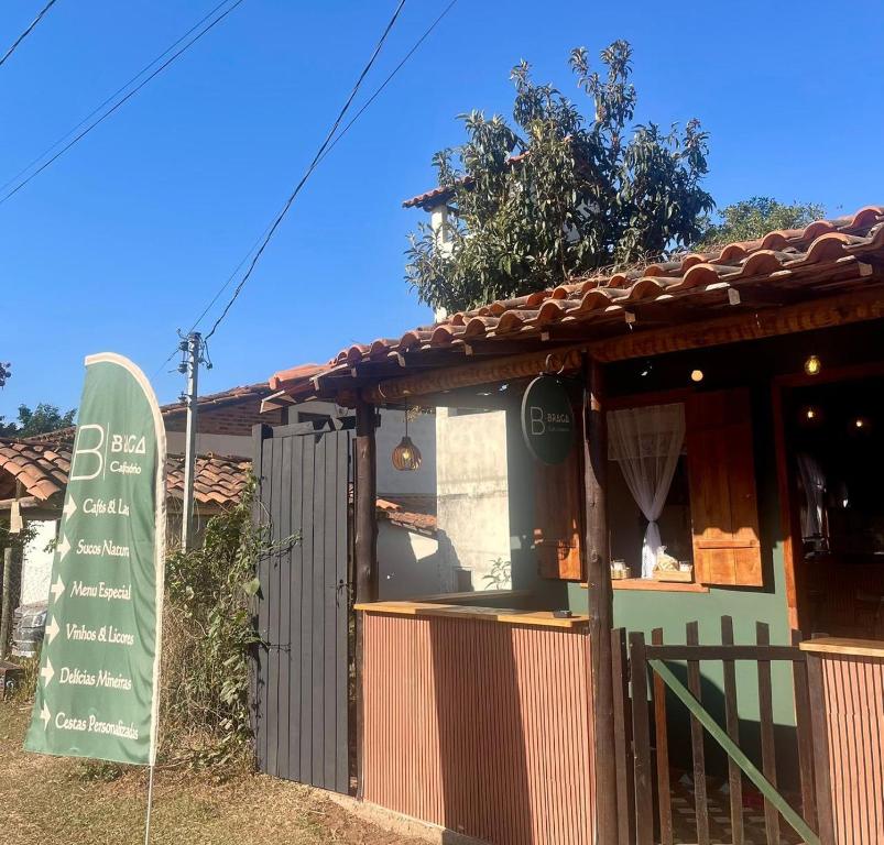 a small building with a sign in front of it at Braga Café & Hospedagem in Sêrro
