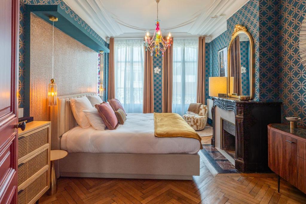 een slaapkamer met een bed, een ladekast en een spiegel bij Villa Emilia - Suites de prestige au coeur de Nancy in Nancy